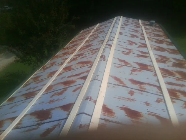 Rusted metal roof panels with new wood purlins before replacement — Storm Damage Roof Repair in Catharpin by Roofing Brothers