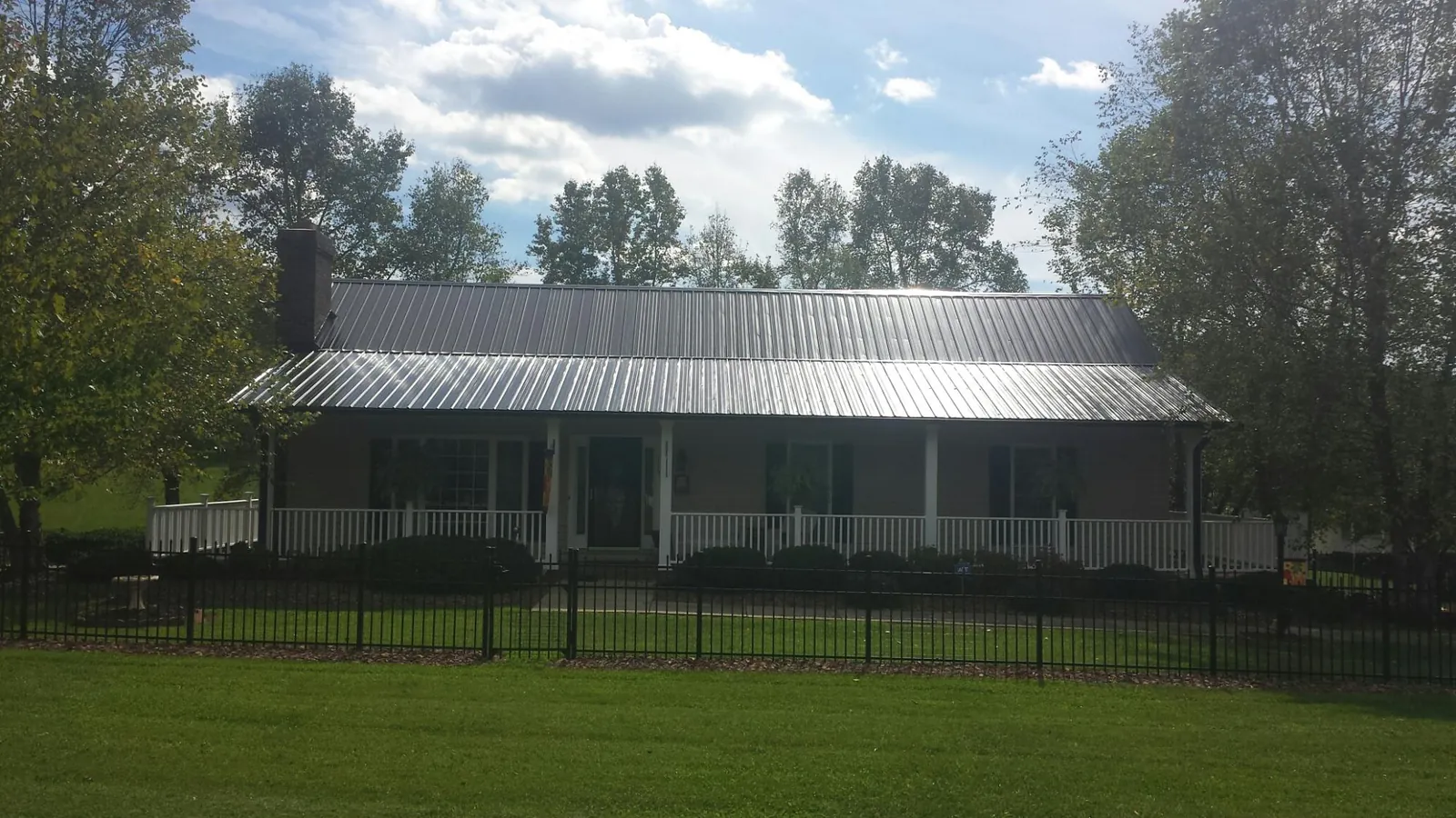 Gray metal roof on a brick ranch with a full width front porch — Gutter Guard Installation work by our crew in Catharpin